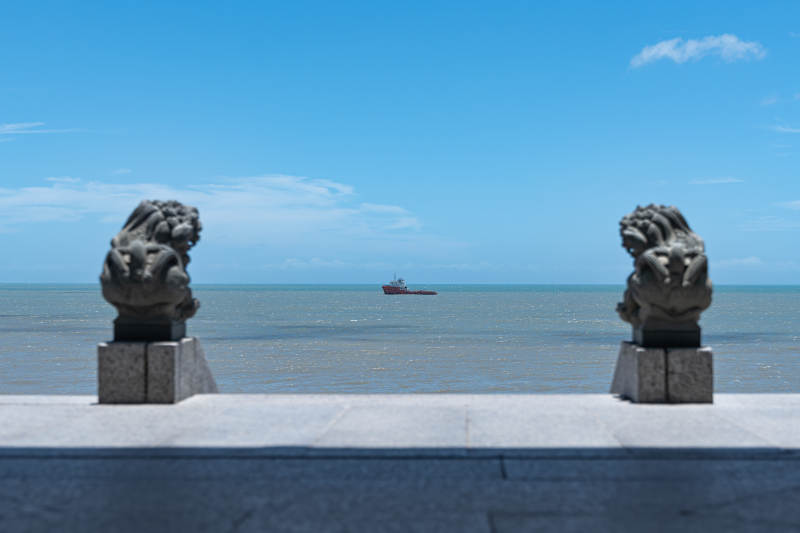 海边石狮与远航船只图片
