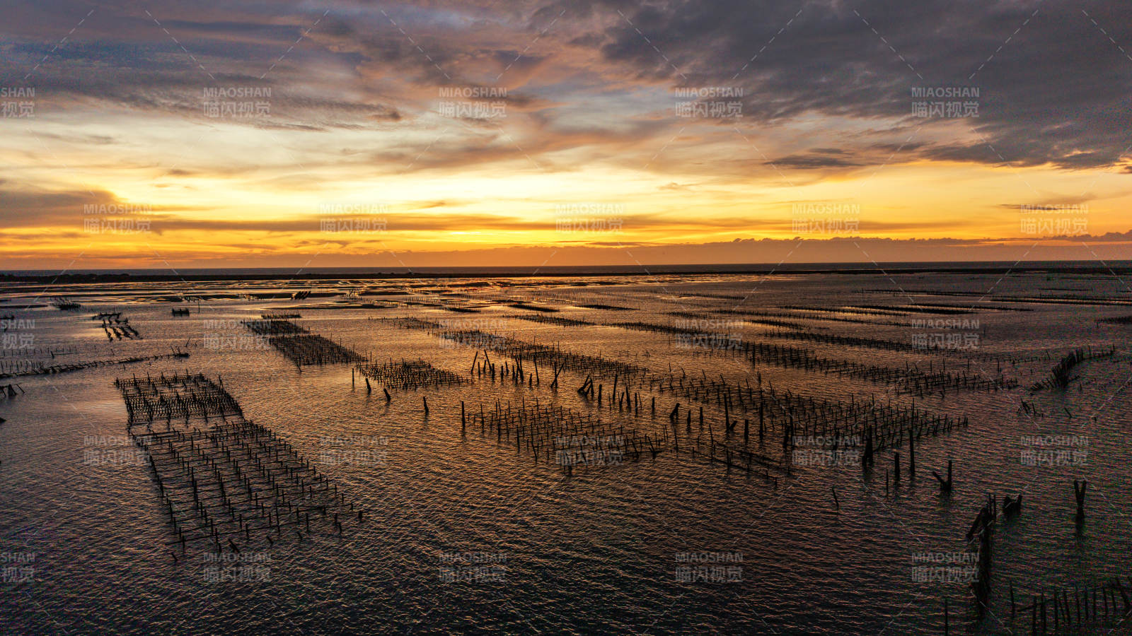 夕阳下的海面竹架风光图片