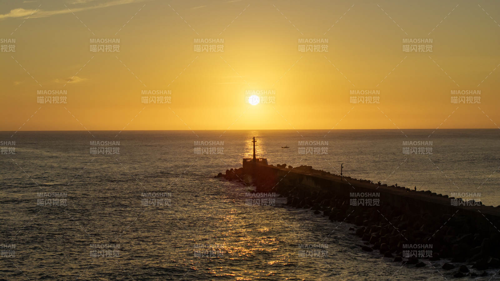 夕阳下的灯塔与海堤图片