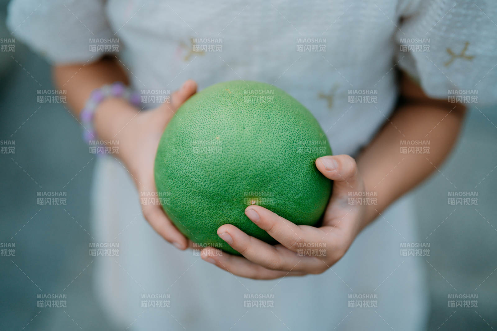 双手捧着绿色柚子果图片