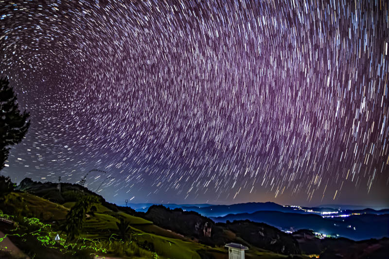 星轨夜空下的山间美景图片
