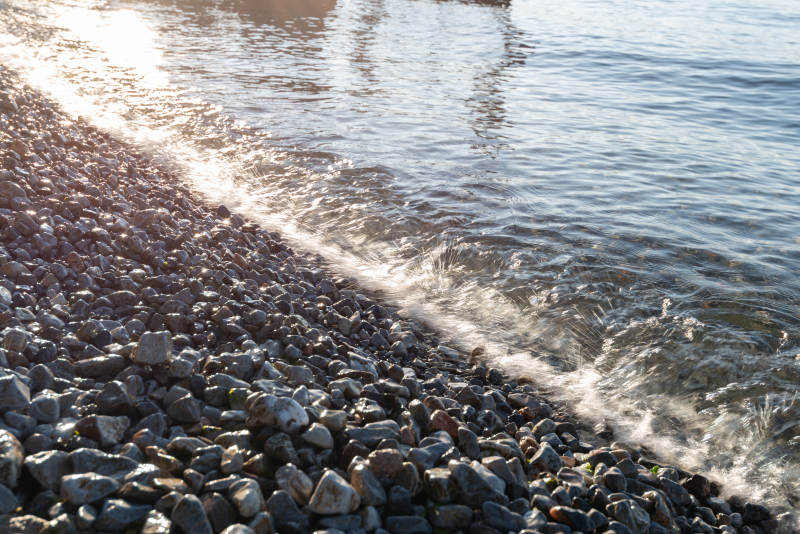 夕阳下的石滩与波浪图片