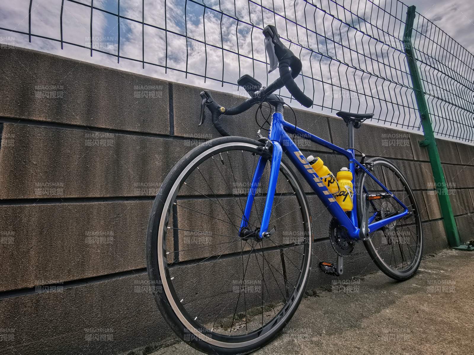 蓝色自行车倚墙而立图片