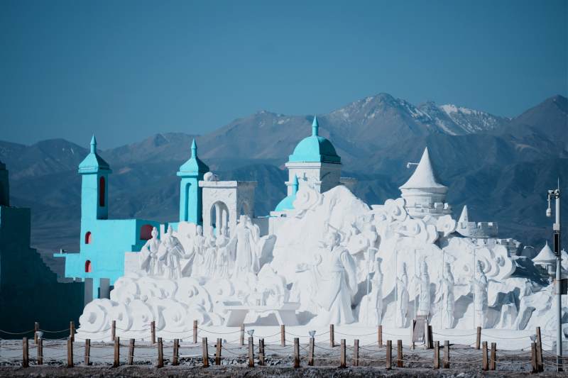 茶卡盐湖的盐雕城堡与雪山背景图片