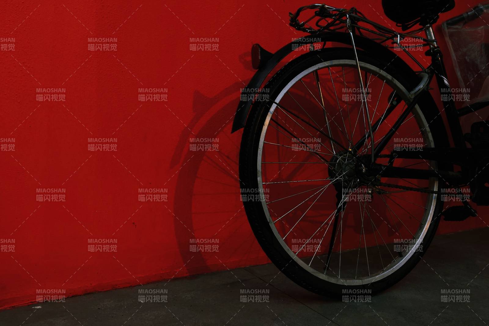 红色墙边的自行车轮图片