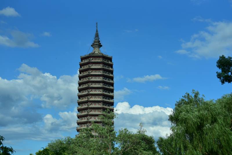 古塔蓝天绿树相映成趣图片