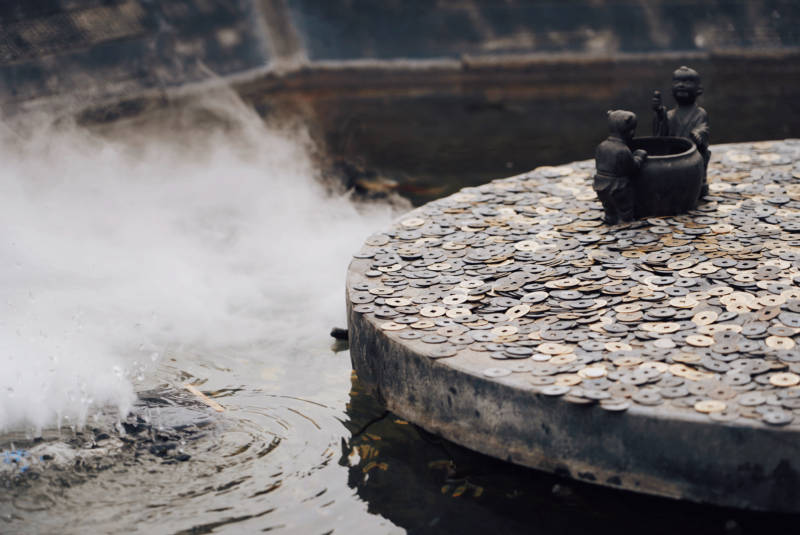 祈福池中的硬币与雕像图片