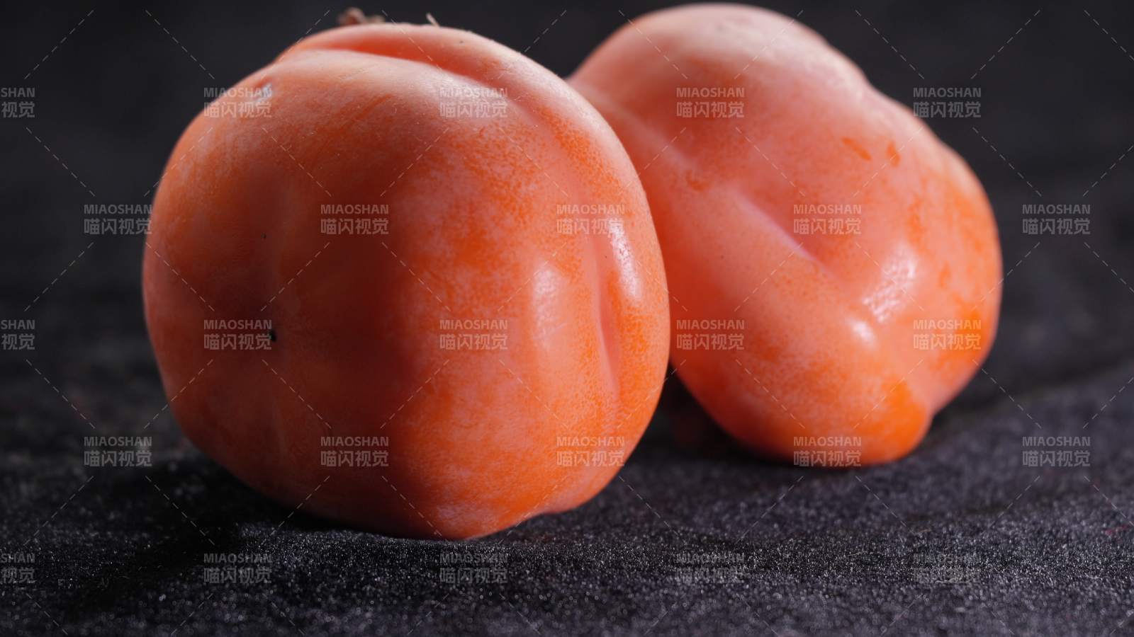 两个橙色柿子的特写图片