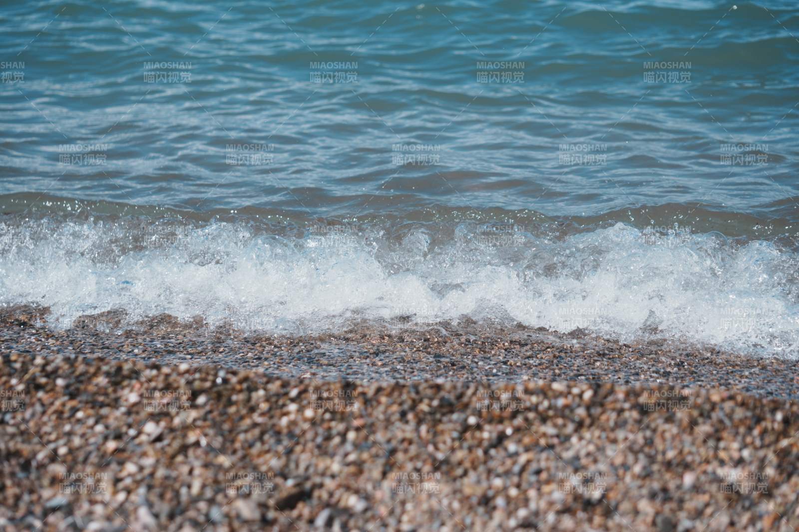 海浪轻拍鹅卵石海滩图片