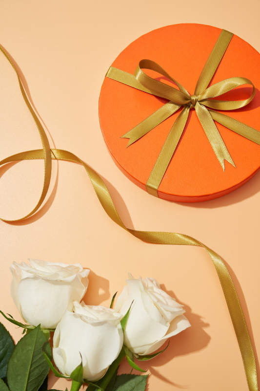 橙色礼盒与白玫瑰花束图片