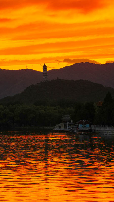 夕阳映照湖畔塔影图片