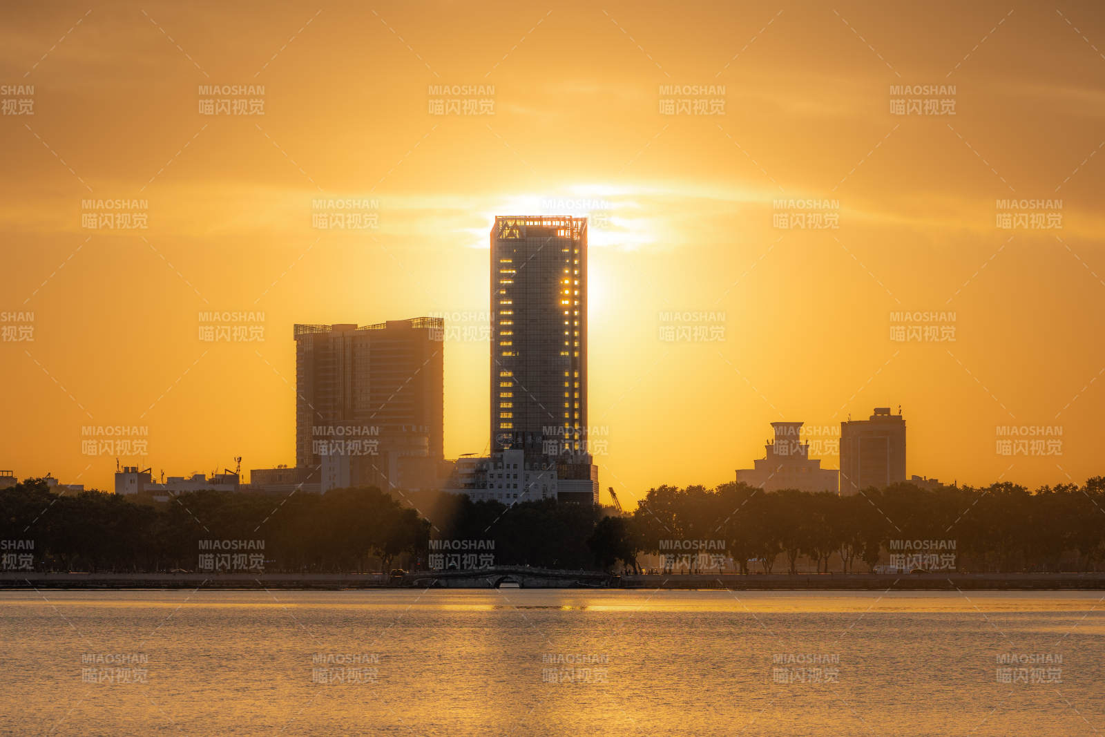 九江甘棠湖夕阳映照城市剪影图片