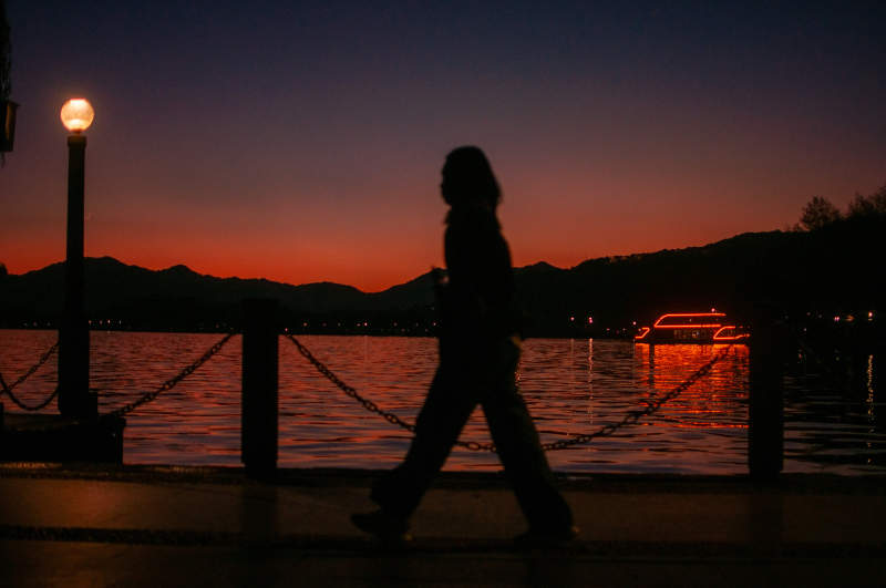 湖畔黄昏 行人剪影图片