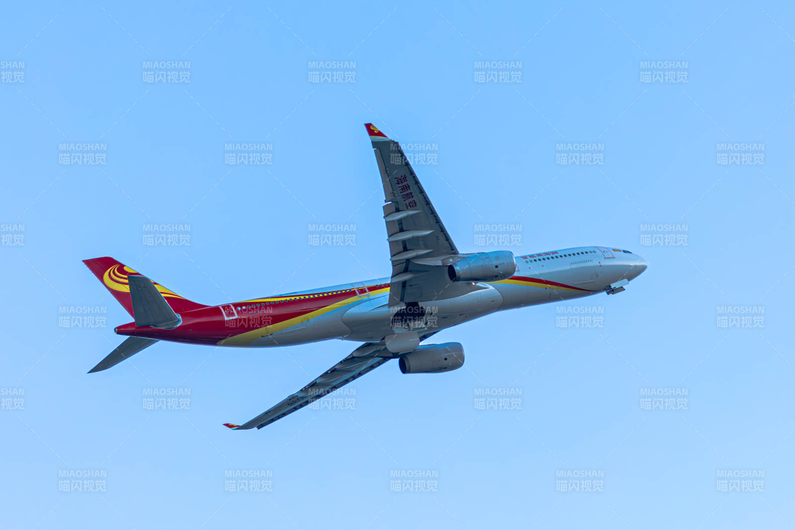 红色涂装的飞机在蓝天中飞行图片