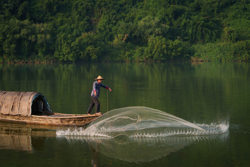 渔夫撒网 湖面宁静图片