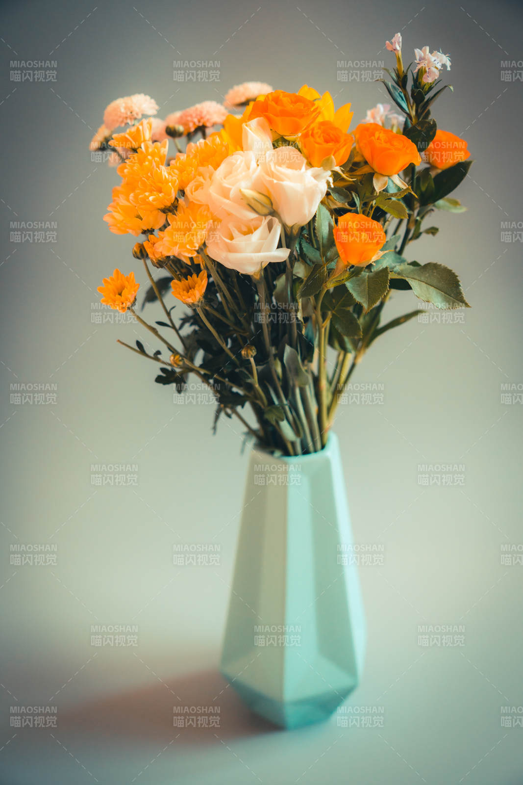 橙色花束与蓝色花瓶图片