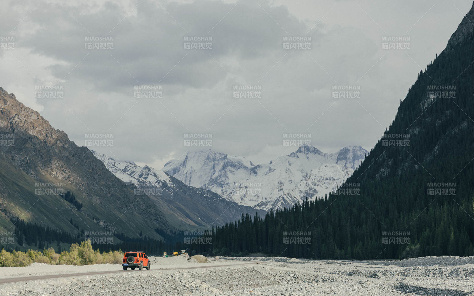 伊犁雪山峡谷中的橙色越野车图片