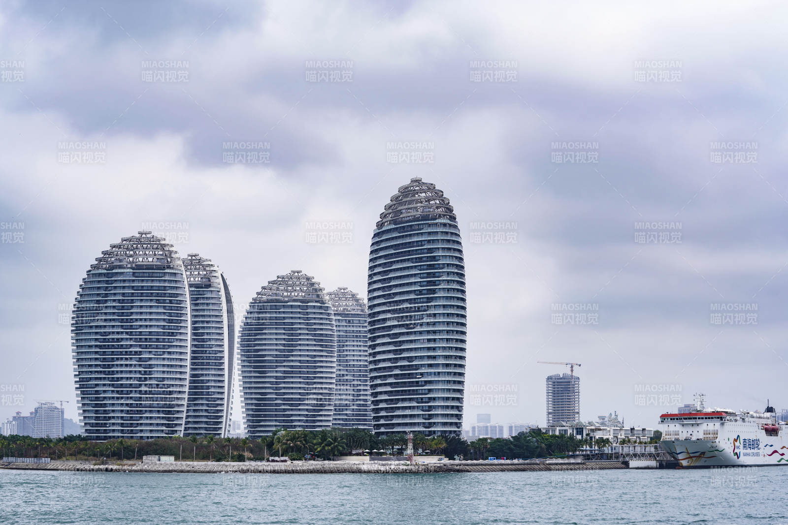 三亚海边现代建筑群与游轮图片