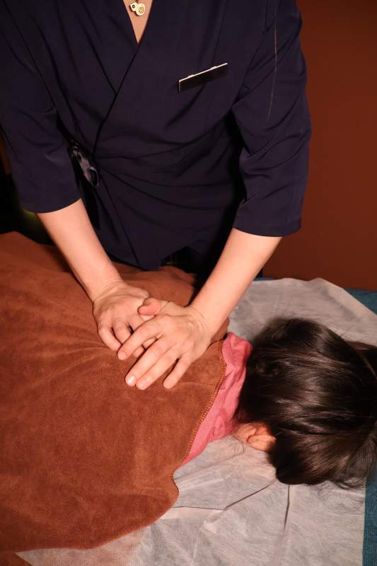 按摩师为顾客进行背部按摩图片