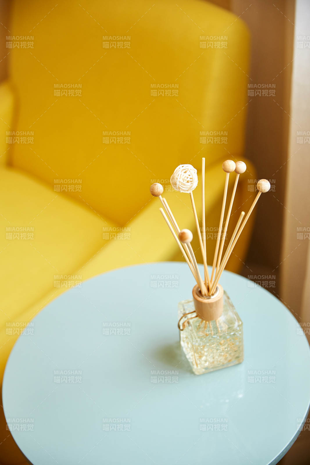 黄色沙发旁的香薰摆件图片