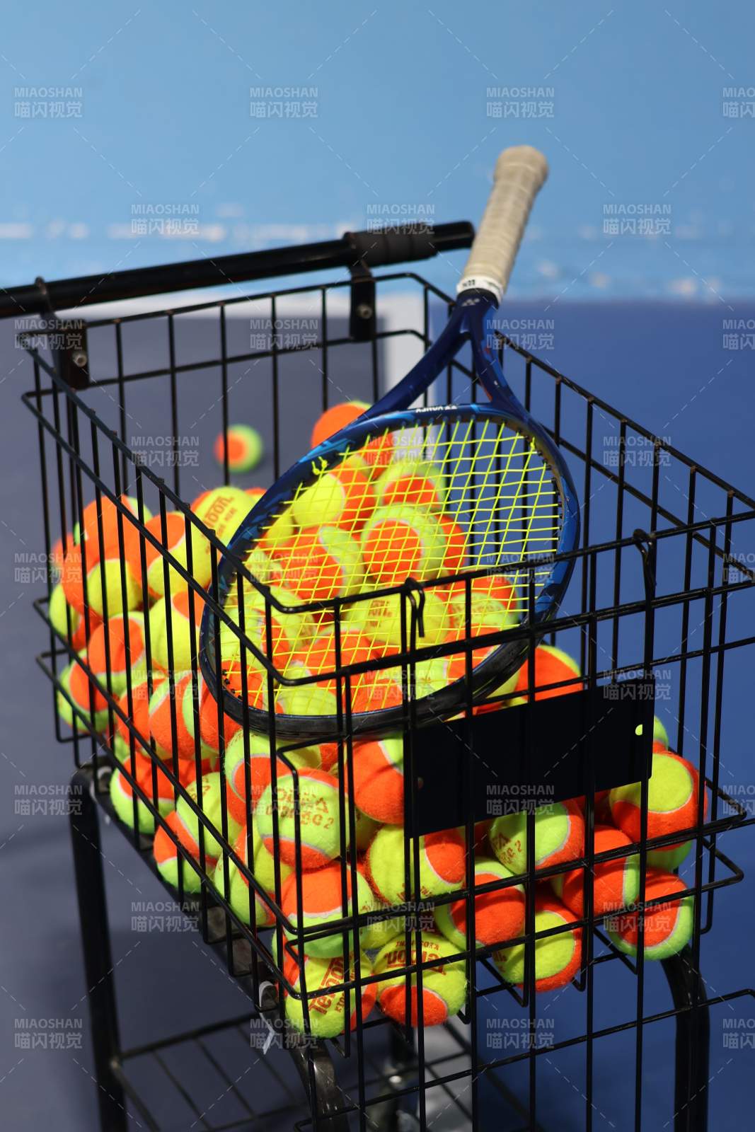 网球拍与球篮特写图片