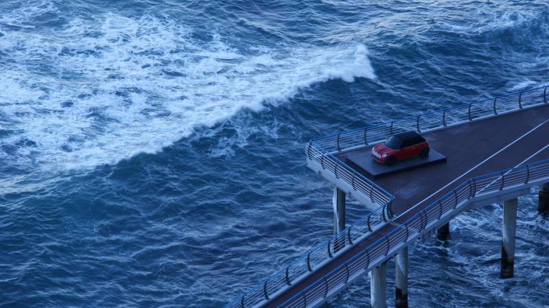 海浪中的桥上红车图片