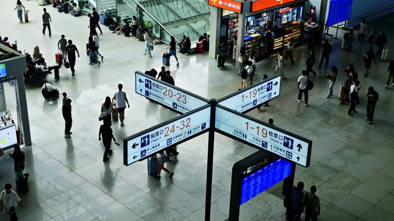 高铁站大厅指示牌下南来北往的旅客图片