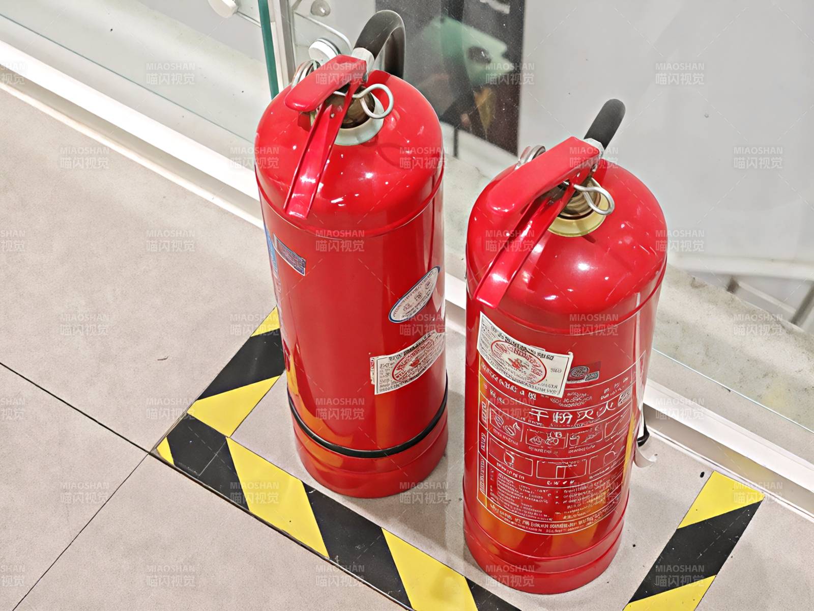 红色灭火器放置于警示区图片
