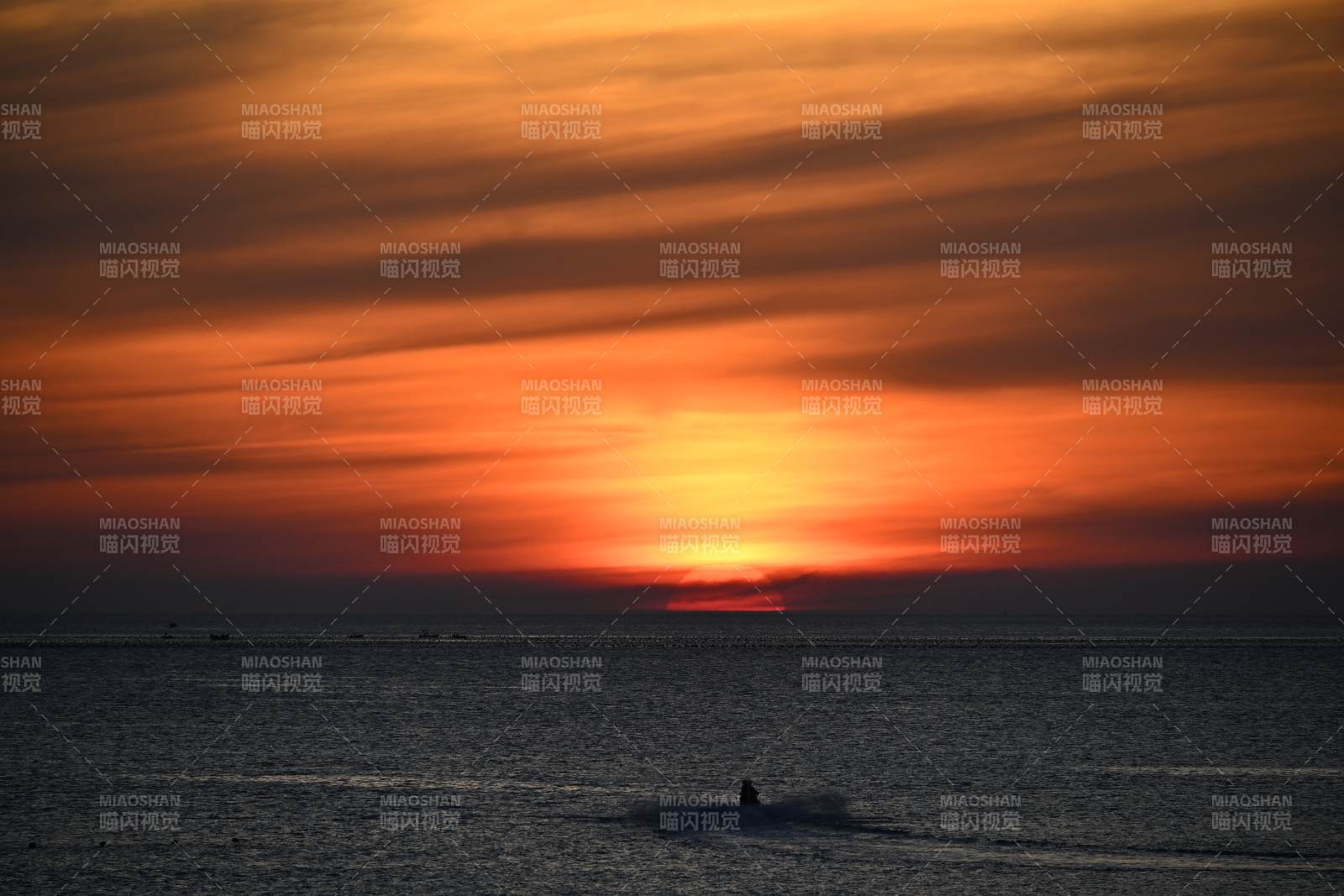夕阳下的海上摩托艇图片