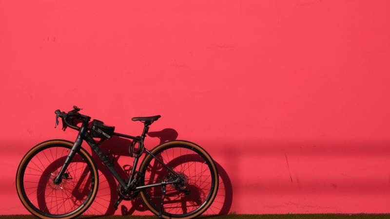 红色墙边的黑色自行车图片