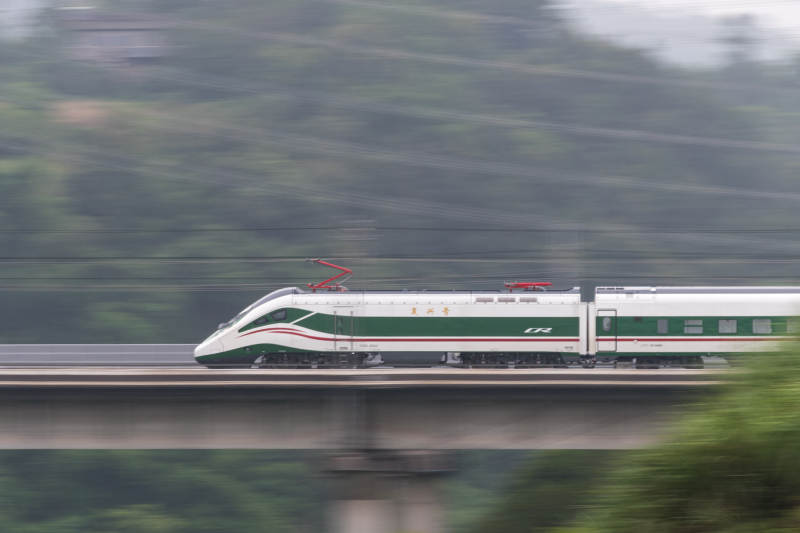 高速列车穿越绿色山林图片