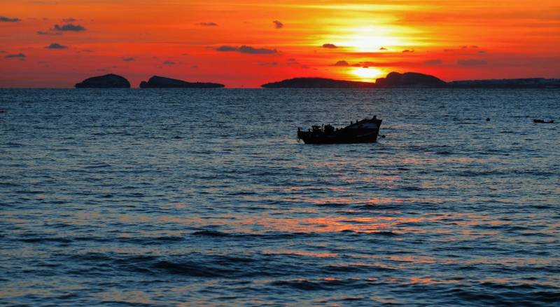 夕阳下的渔船与海岛图片