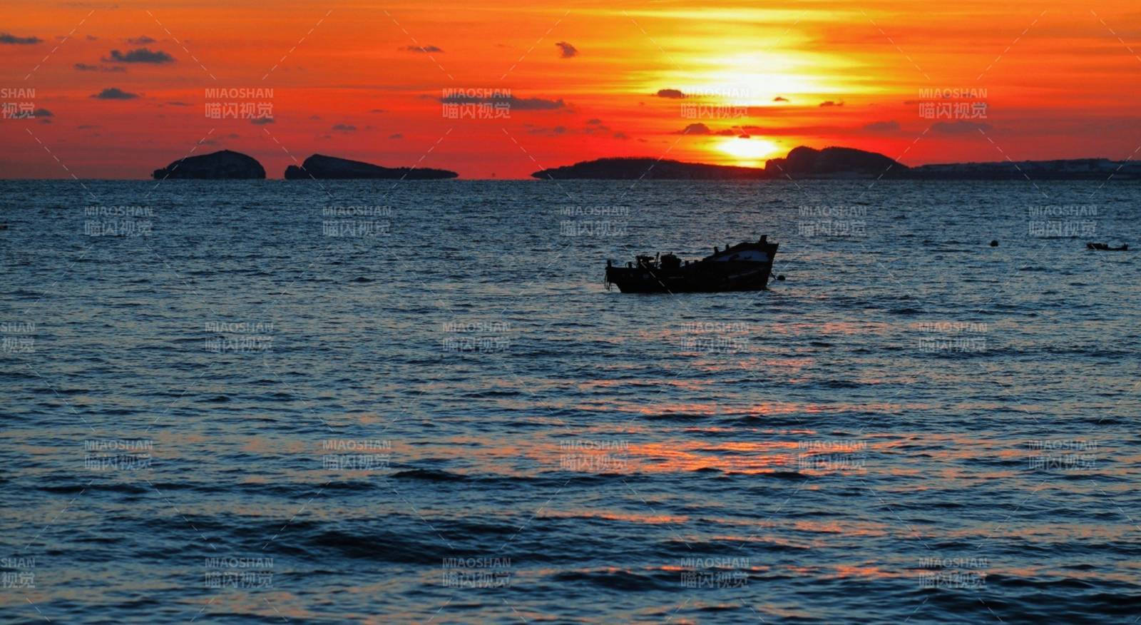 夕阳下的渔船与海岛图片