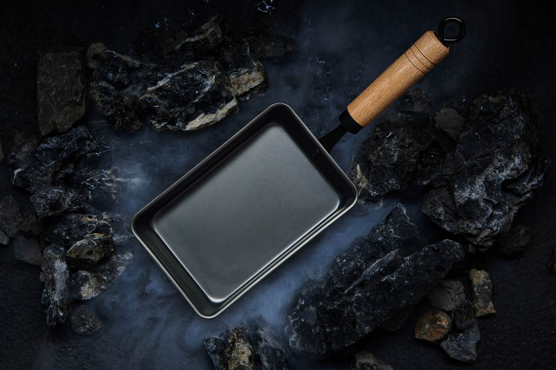 铸铁煎锅与岩石背景图片