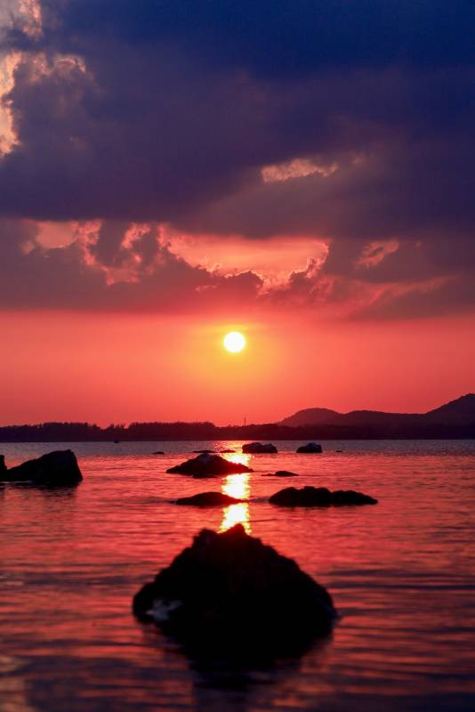 夕阳映海 岩石剪影图片