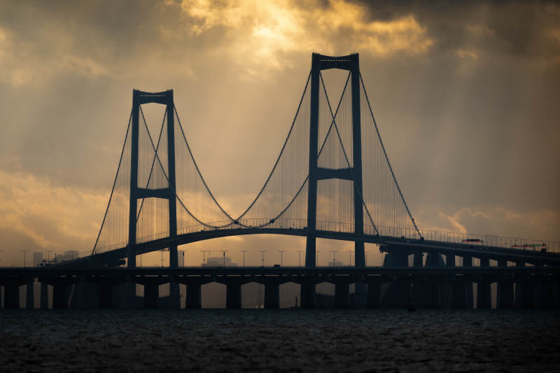 日出下的大桥剪影图片