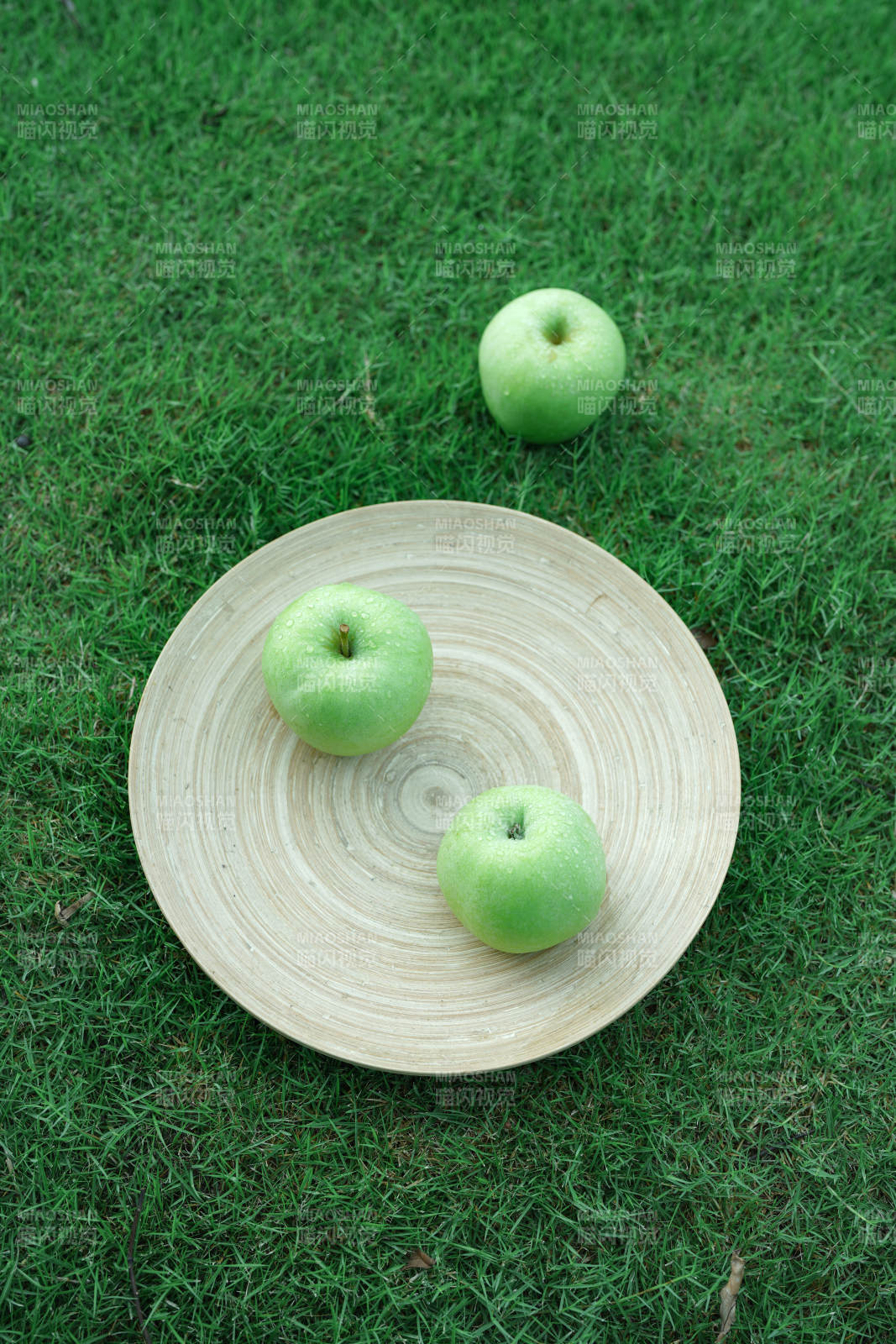 绿苹果与竹盘的自然静谧图片
