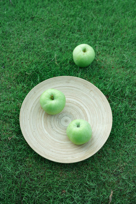 绿苹果与竹盘的自然静谧图片