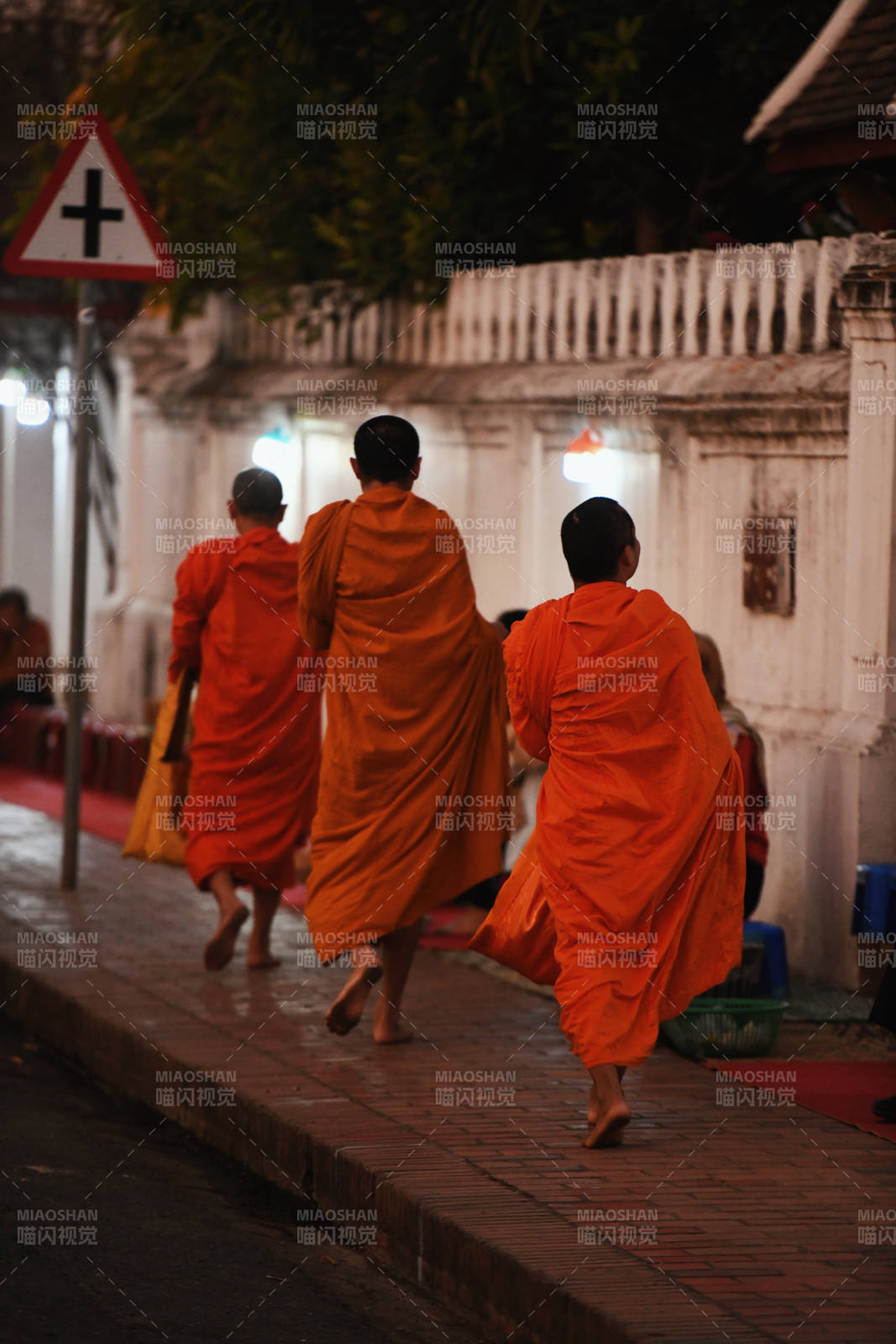 僧侣行走在夜晚的街道上图片