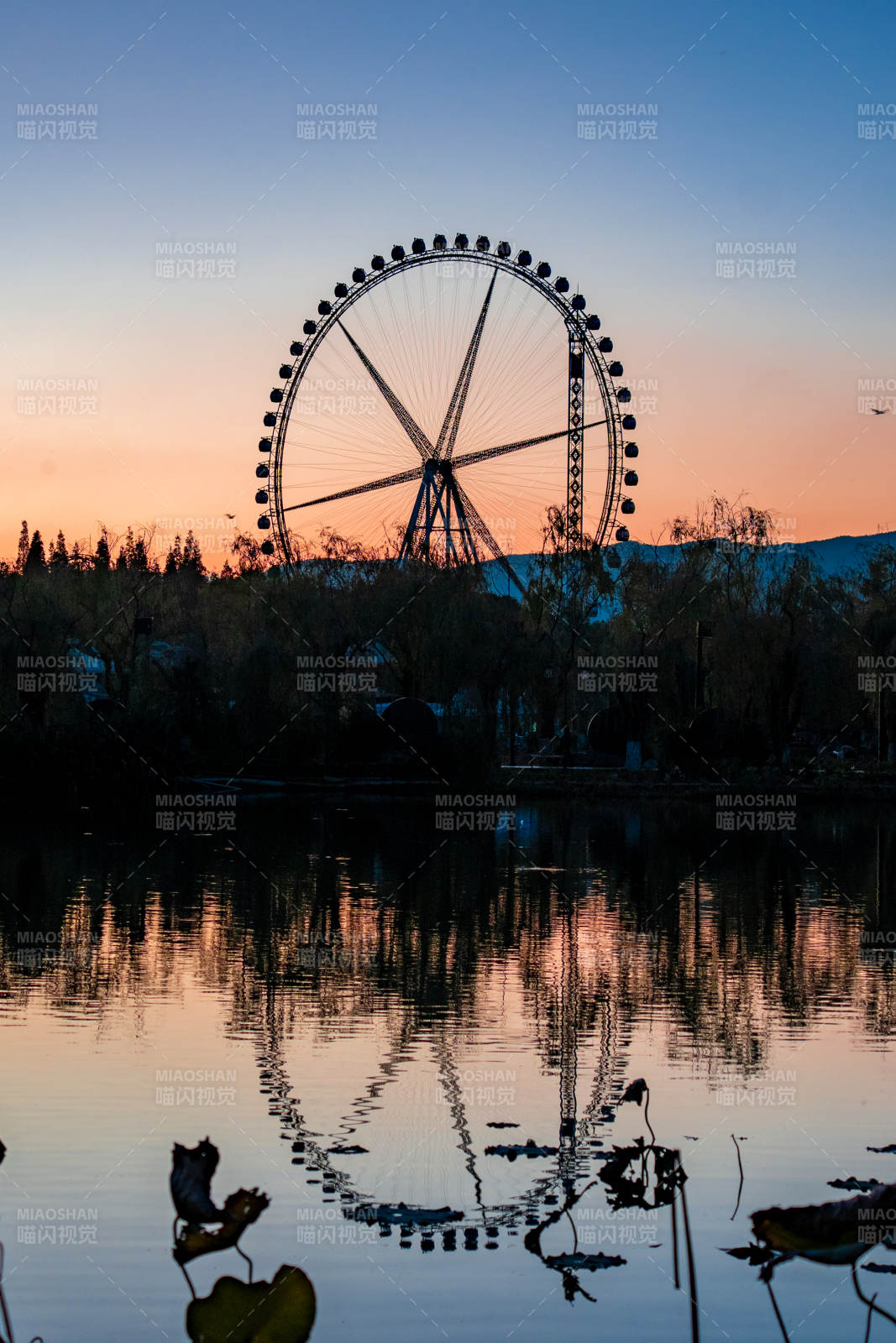 夕阳下的摩天轮倒影图片