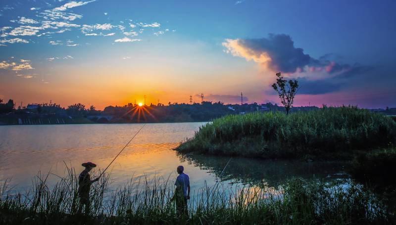 夕阳下的湖畔垂钓图片