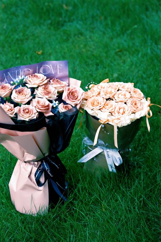 玫瑰花束与花桶静置草地图片