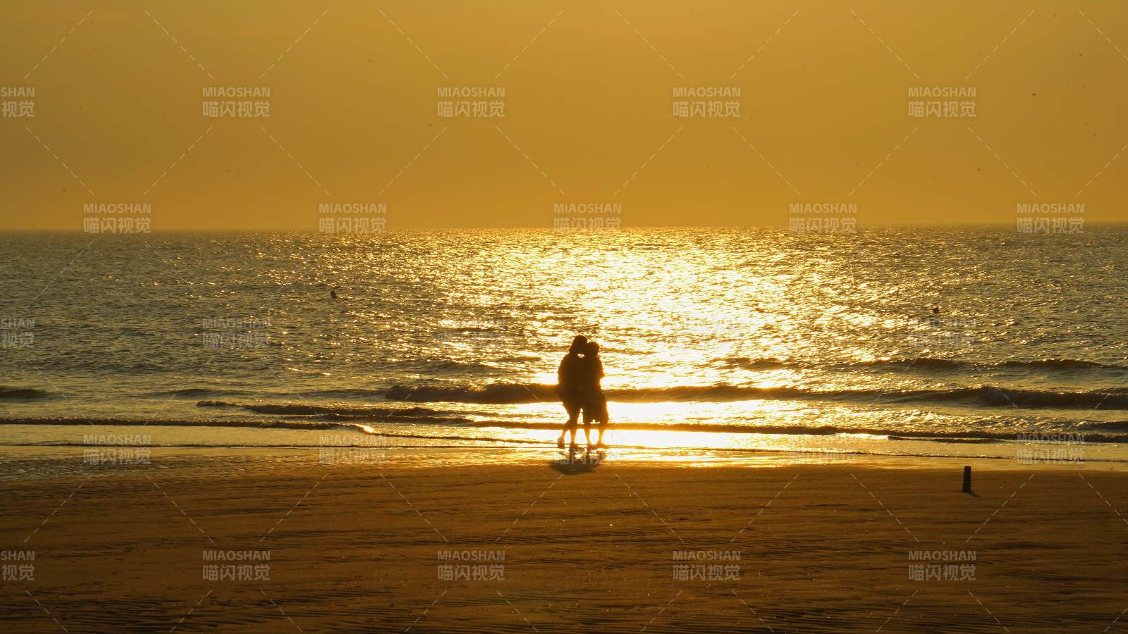 夕阳下的海滩情侣剪影图片