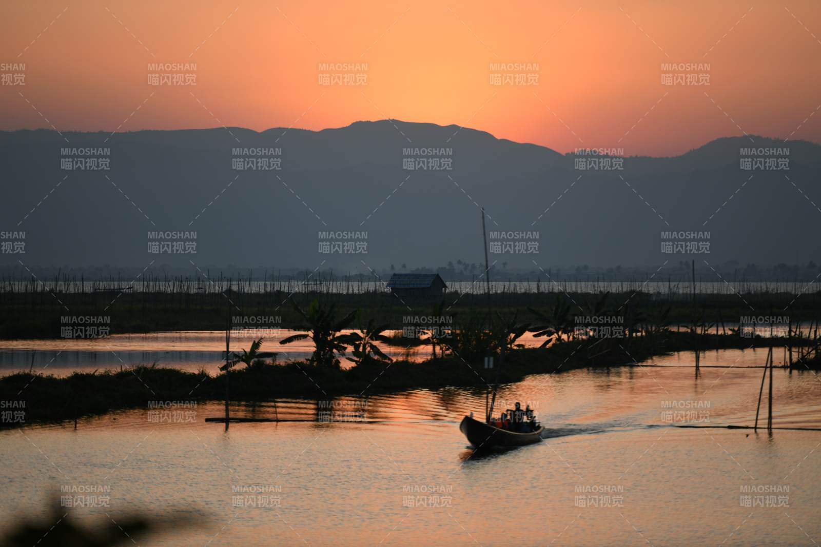 夕阳下的湖畔小舟图片