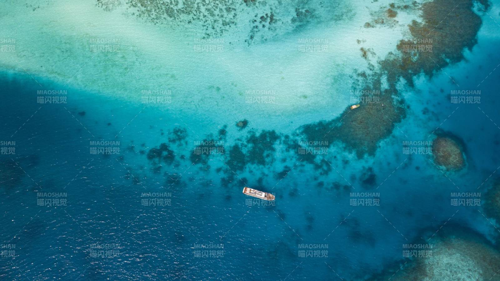 西沙群岛珊瑚礁上的小船航拍图图片