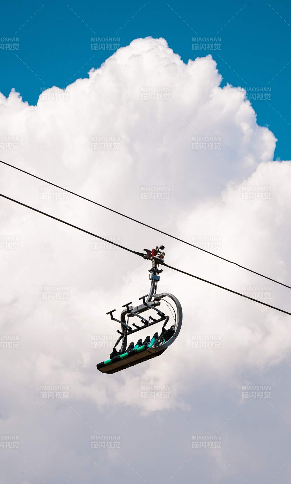 蓝天白云下的缆车座椅图片