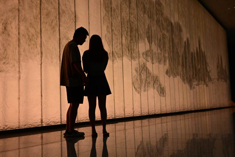 情侣在光影墙前相依图片