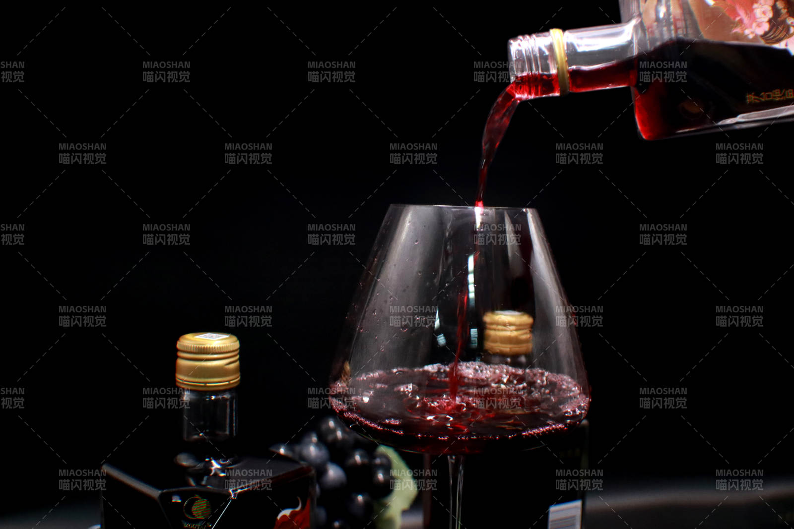 红酒倒入杯中 葡萄点缀图片