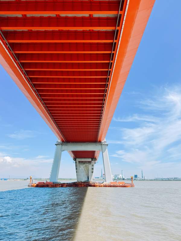 红色大桥下的蓝天碧水图片