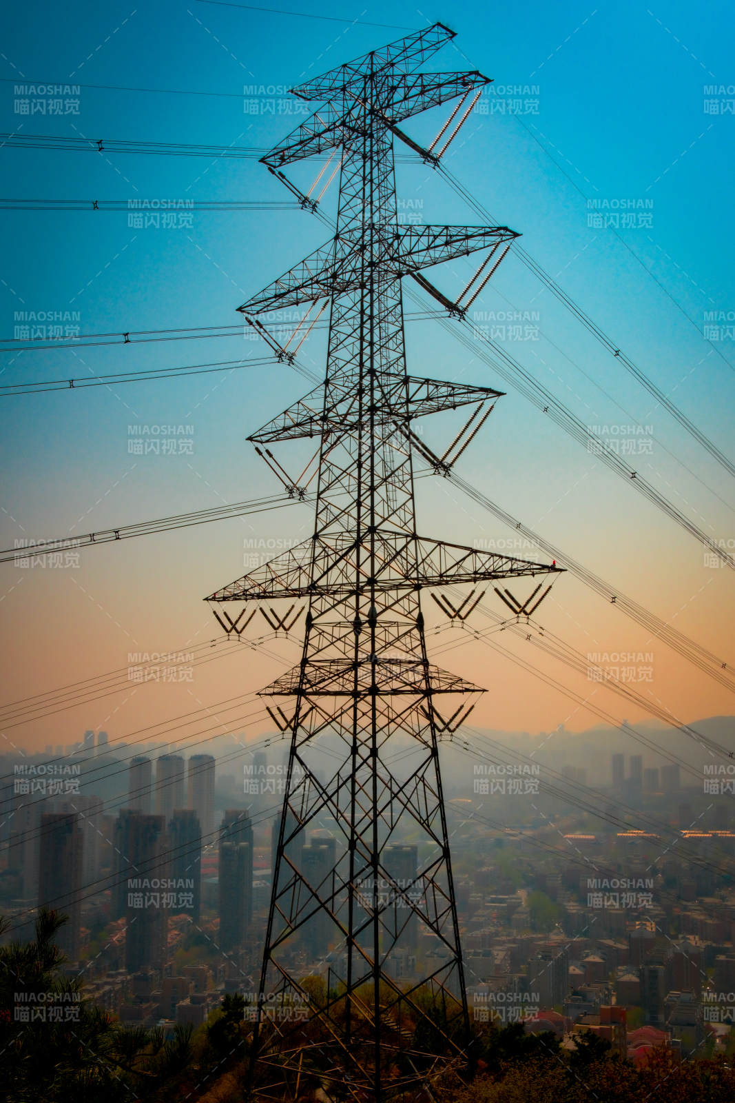 城市黄昏下的高压电塔图片